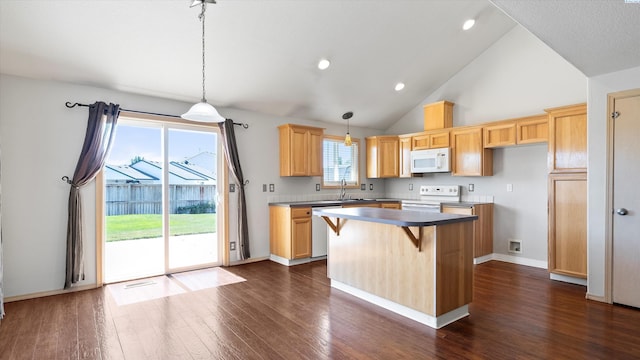 5704 Taft Dr, Pasco, WA 99301 - kitchen featuring white appliances, dark wood-style flooring, a center island, hanging light fixtures, and a breakfast bar area