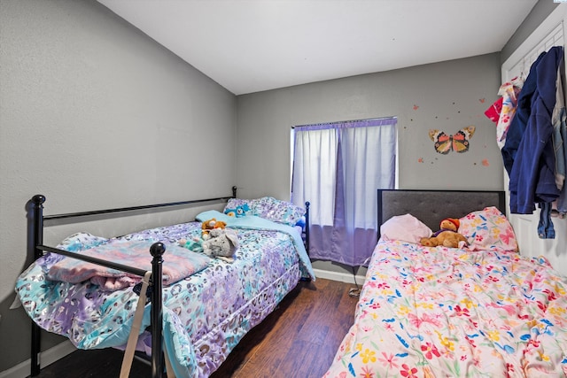 bedroom featuring baseboards and wood finished floors