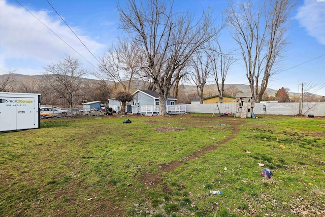 view of yard featuring a playground, fence, and a mountain view