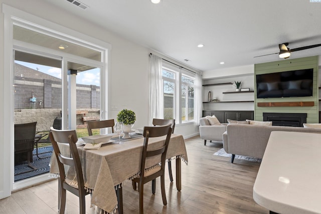 dining space featuring visible vents, recessed lighting, a fireplace, and light wood-type flooring