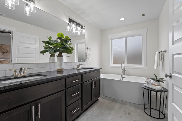 full bathroom featuring a sink, visible vents, a soaking tub, and double vanity