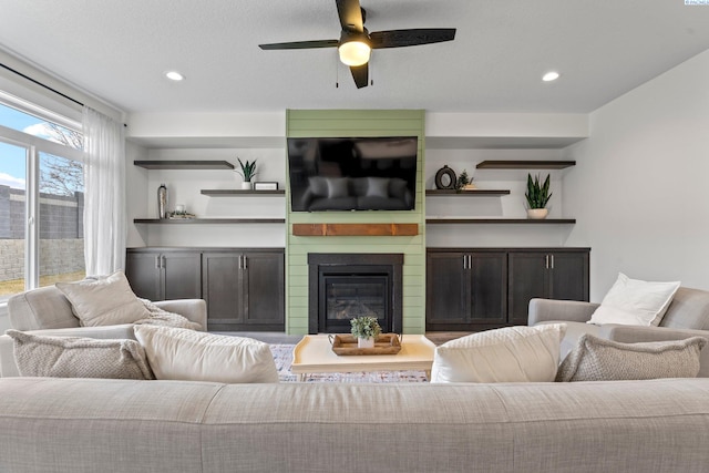 living area featuring recessed lighting, ceiling fan, and a fireplace