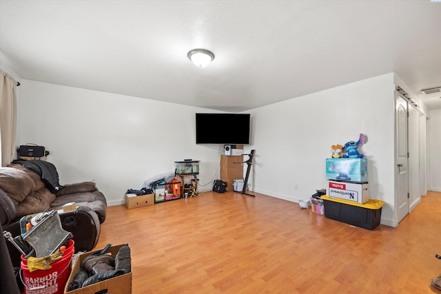 living room featuring baseboards, visible vents, and wood finished floors