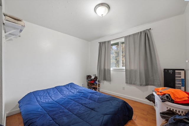 bedroom featuring baseboards and wood finished floors