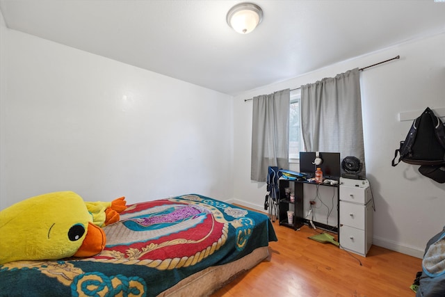 bedroom with light wood-style flooring and baseboards