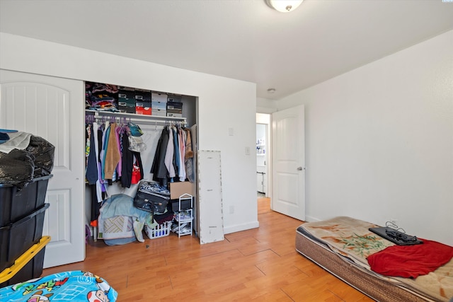 bedroom featuring a closet, baseboards, and wood finished floors