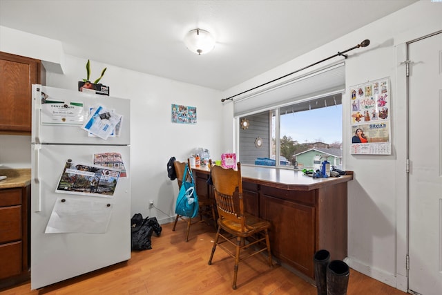 office area with light wood-style flooring and baseboards