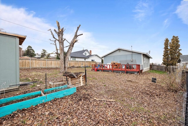 view of yard with a fenced backyard, a vegetable garden, and a deck