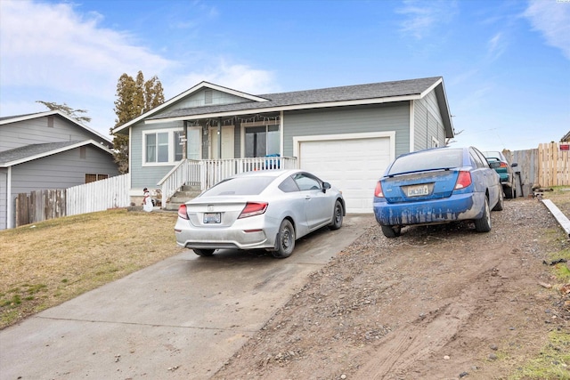 ranch-style house featuring a porch, an attached garage, fence, driveway, and a front yard