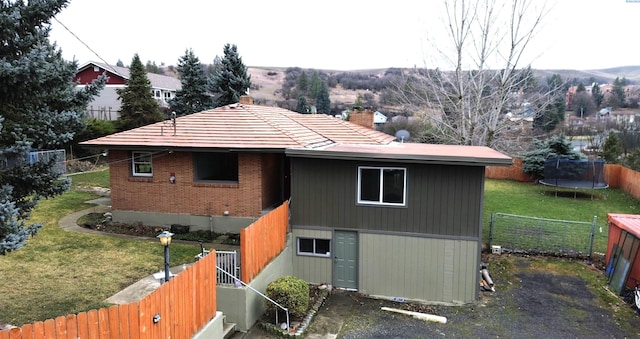 exterior space with a trampoline and a lawn