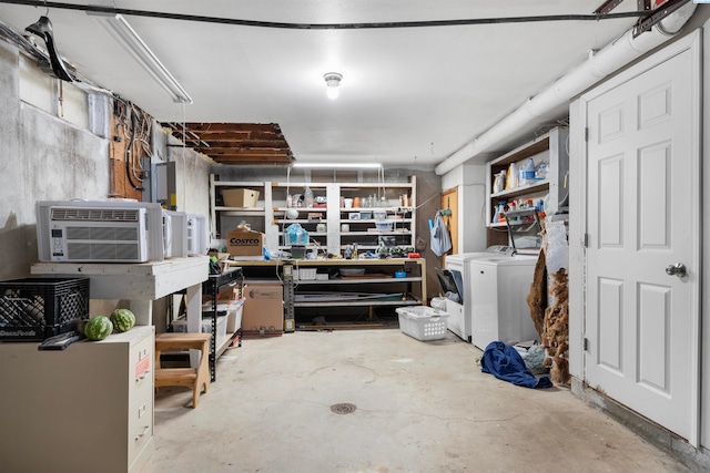 basement with a wall mounted air conditioner, a workshop area, and independent washer and dryer