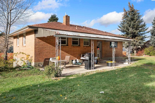 rear view of house featuring a patio area and a lawn