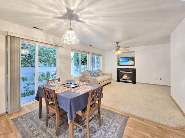 2650 Dornoch Pl, Richland, WA 99354 - dining area featuring a fireplace with flush hearth, a chandelier, baseboards, and light wood-type flooring