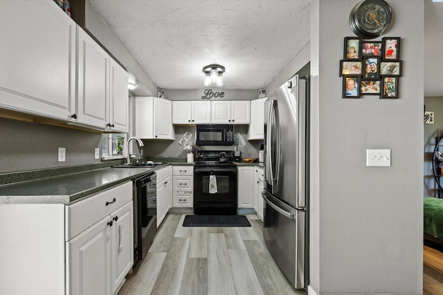 4403 S Ione St, Kennewick, WA 99337 - kitchen with black appliances, light wood-style flooring, dark countertops, a sink, and white cabinets