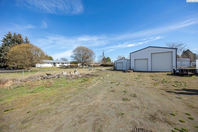 view of yard with an outbuilding, fence, and a garage