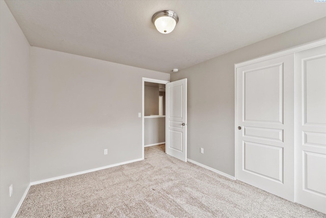 unfurnished bedroom with carpet floors and baseboards
