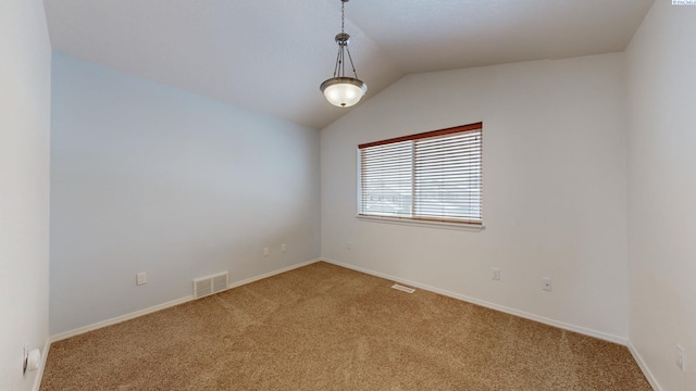 spare room featuring carpet floors and vaulted ceiling