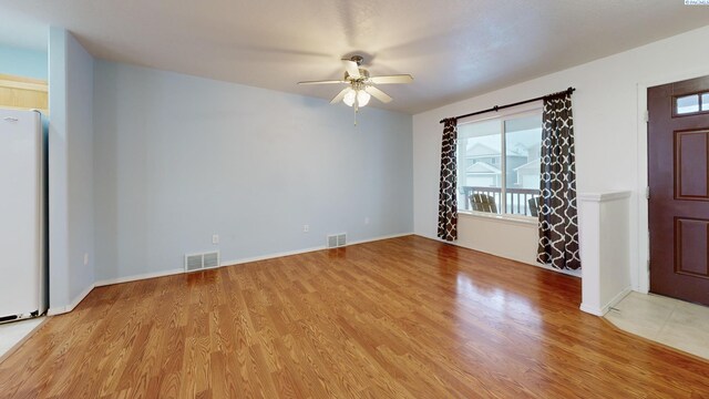 spare room with ceiling fan, visible vents, and light wood-style flooring