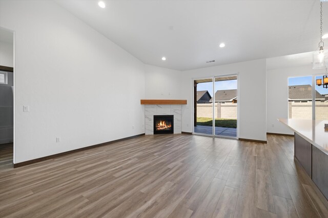 6701 Sockeye Ln, Pasco, WA 99301 - unfurnished living room featuring a tiled fireplace and hardwood / wood-style floors