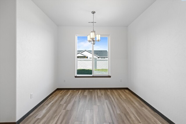 6701 Sockeye Ln, Pasco, WA 99301 - unfurnished dining area with light hardwood / wood-style floors and a notable chandelier