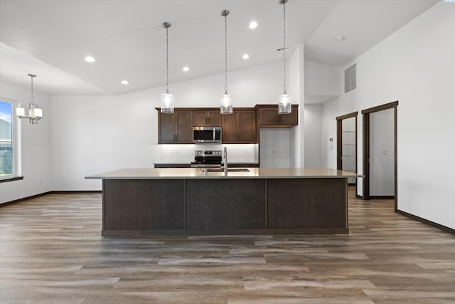 6701 Sockeye Ln, Pasco, WA 99301 - kitchen with dark brown cabinets, appliances with stainless steel finishes, dark hardwood / wood-style flooring, pendant lighting, and a kitchen island with sink