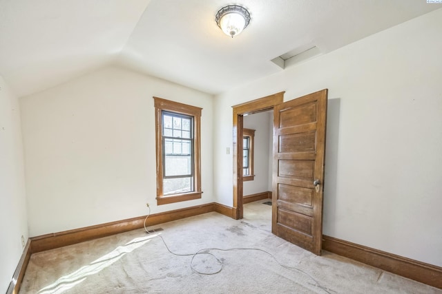 interior space featuring vaulted ceiling and light carpet