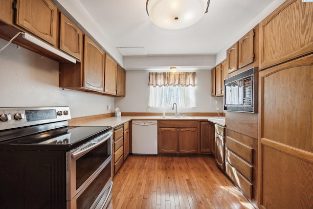 kitchen with sink, light hardwood / wood-style flooring, dishwasher, double oven range, and black microwave