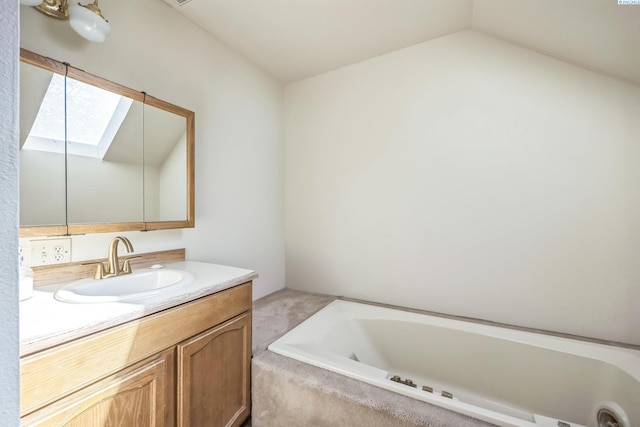 bathroom featuring vanity, lofted ceiling with skylight, and a relaxing tiled tub