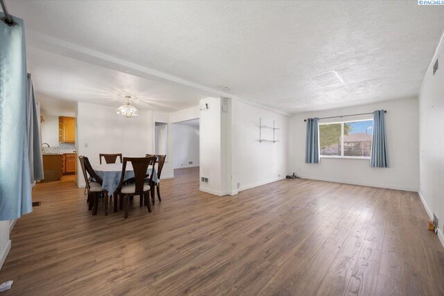 1925 Everest Ave, Richland, WA 99354 - dining space featuring a chandelier, a textured ceiling, wood finished floors, and baseboards