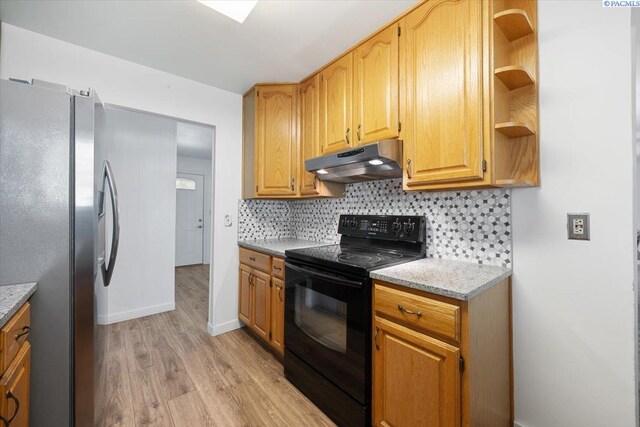 1925 Everest Ave, Richland, WA 99354 - kitchen featuring under cabinet range hood, black range with electric cooktop, freestanding refrigerator, light wood-style flooring, and decorative backsplash