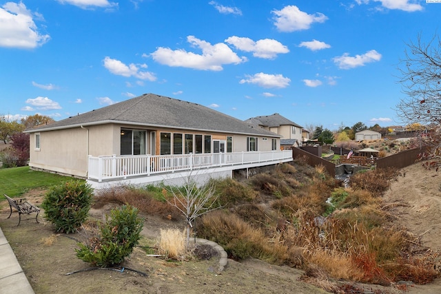 rear view of house featuring a wooden deck