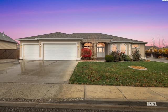 view of front facade with a yard and a garage