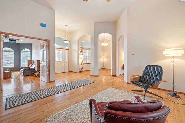 entrance foyer featuring hardwood / wood-style flooring, ceiling fan, and a towering ceiling