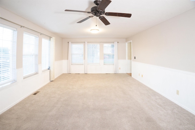 empty room featuring ceiling fan and light carpet