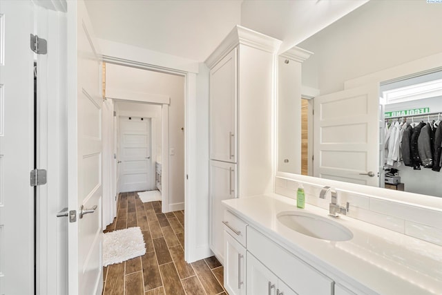 6514 Eagle Crest Dr, Pasco, WA 99301 - bathroom with a spacious closet, baseboards, vanity, and wood finish floors