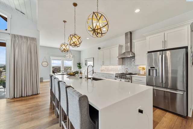 6514 Eagle Crest Dr, Pasco, WA 99301 - kitchen with recessed lighting, an inviting chandelier, wall chimney range hood, a sink, and appliances with stainless steel finishes
