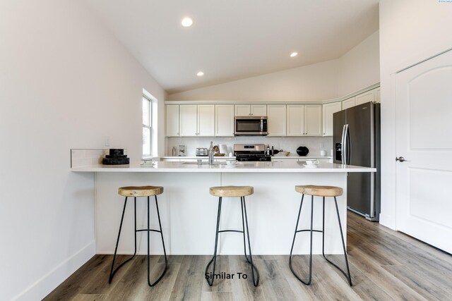 2880 S Osborne St, Kennewick, WA 99338 - kitchen featuring a peninsula, white cabinets, appliances with stainless steel finishes, and a kitchen bar