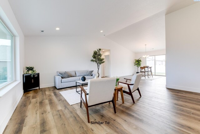 2880 S Osborne St, Kennewick, WA 99338 - living room with baseboards, vaulted ceiling, an inviting chandelier, and wood finished floors