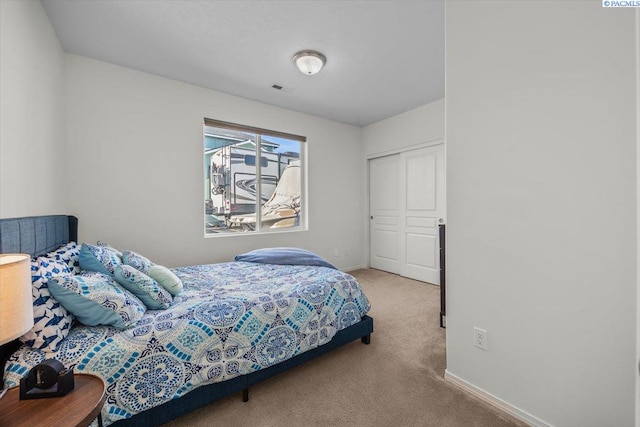 bedroom featuring carpet flooring, baseboards, and a closet