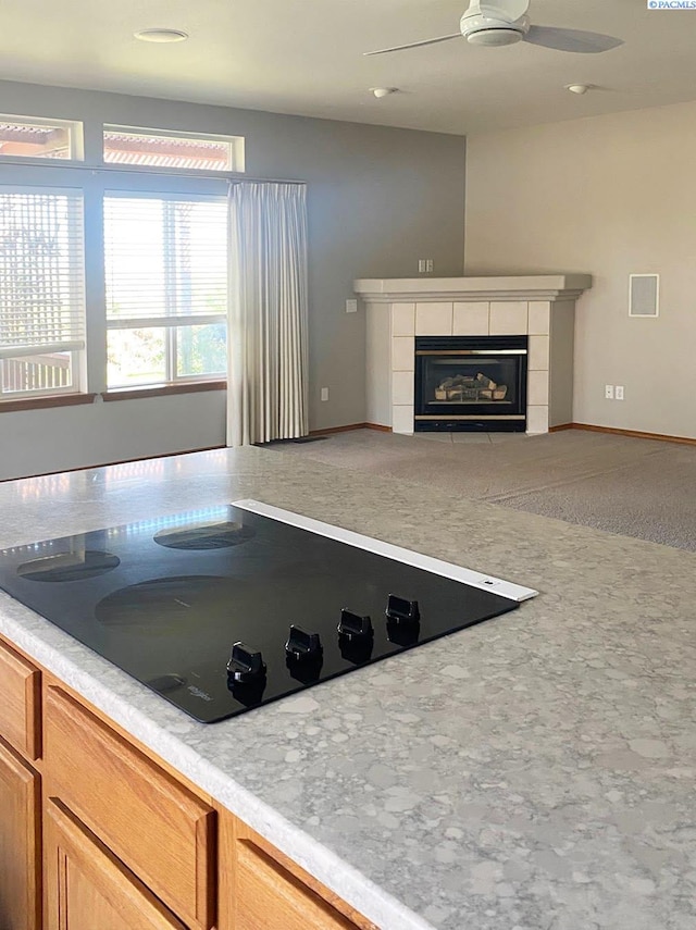 2665 Maidstone St, Richland, WA 99354 - kitchen with black electric stovetop, ceiling fan, a fireplace, open floor plan, and light countertops