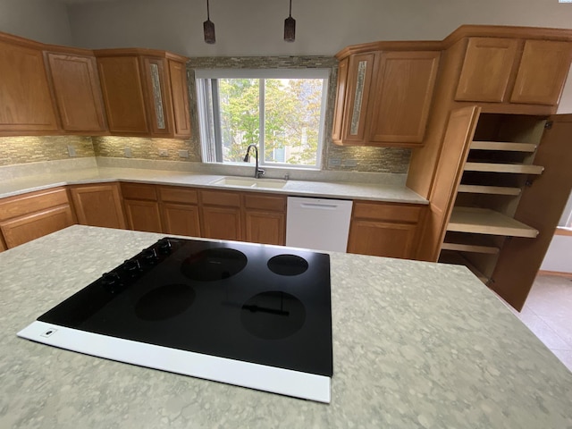 2665 Maidstone St, Richland, WA 99354 - kitchen with a sink, white dishwasher, decorative backsplash, light countertops, and glass insert cabinets