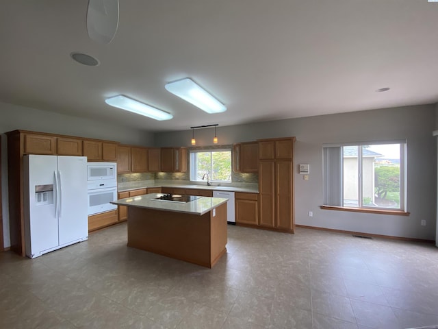 2665 Maidstone St, Richland, WA 99354 - kitchen with white appliances, a sink, a kitchen island, tasteful backsplash, and light countertops
