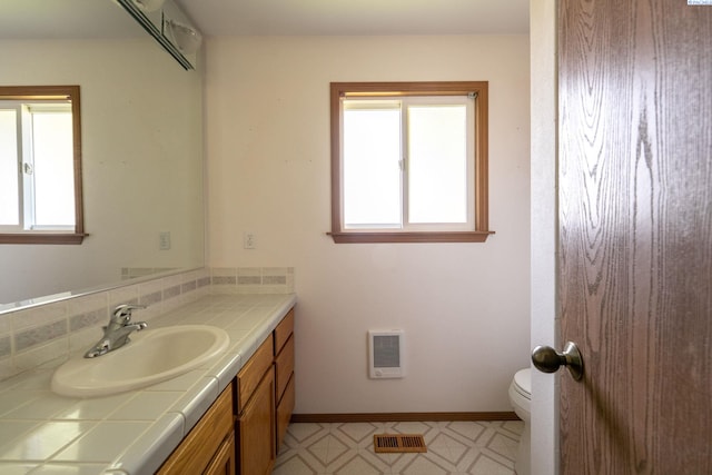 97010 W Good Rd, Prosser, WA 99350 - bathroom with vanity, heating unit, toilet, baseboards, and tile patterned floors