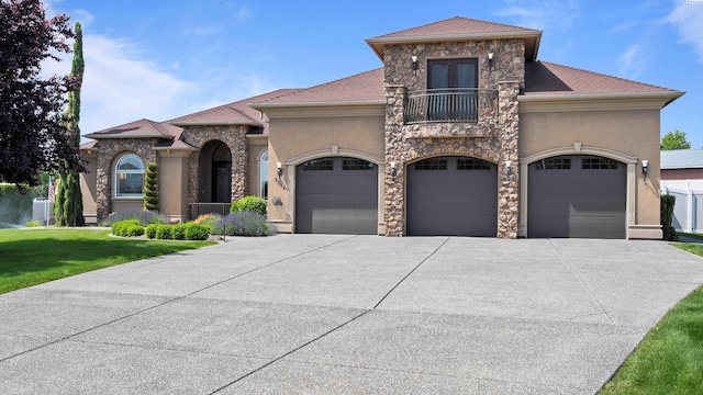 3304 Sorento Ct, Pasco, WA 99301 - view of front of house with a balcony, driveway, an attached garage, a front lawn, and stucco siding