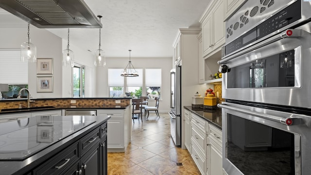 3304 Sorento Ct, Pasco, WA 99301 - kitchen with under cabinet range hood, appliances with stainless steel finishes, a sink, backsplash, and white cabinetry