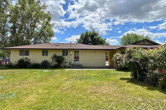 back of property with a lawn, a patio area, and entry steps