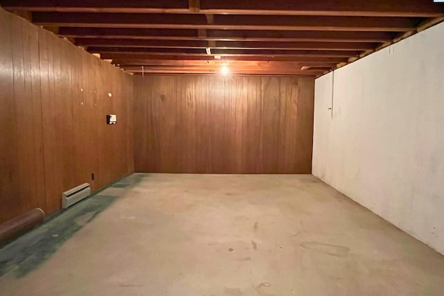 finished basement featuring a baseboard radiator and wood walls