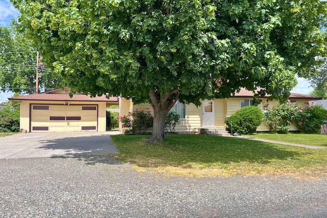obstructed view of property featuring driveway, a front yard, a garage, and entry steps
