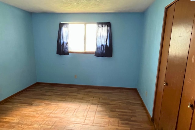 empty room with light wood-style flooring and baseboards