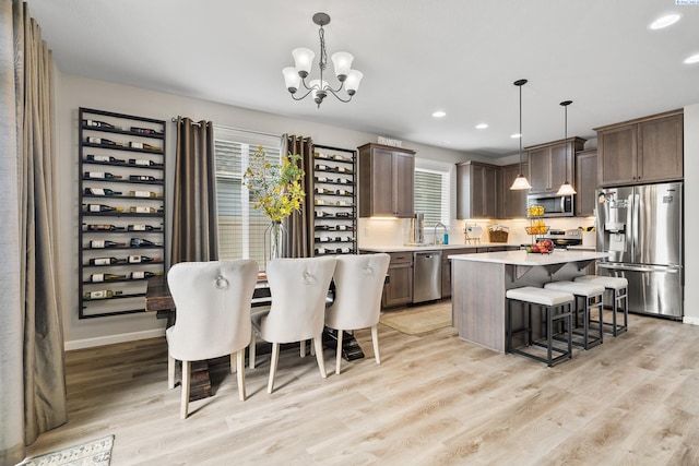 kitchen with hanging light fixtures, a breakfast bar, a center island, and appliances with stainless steel finishes